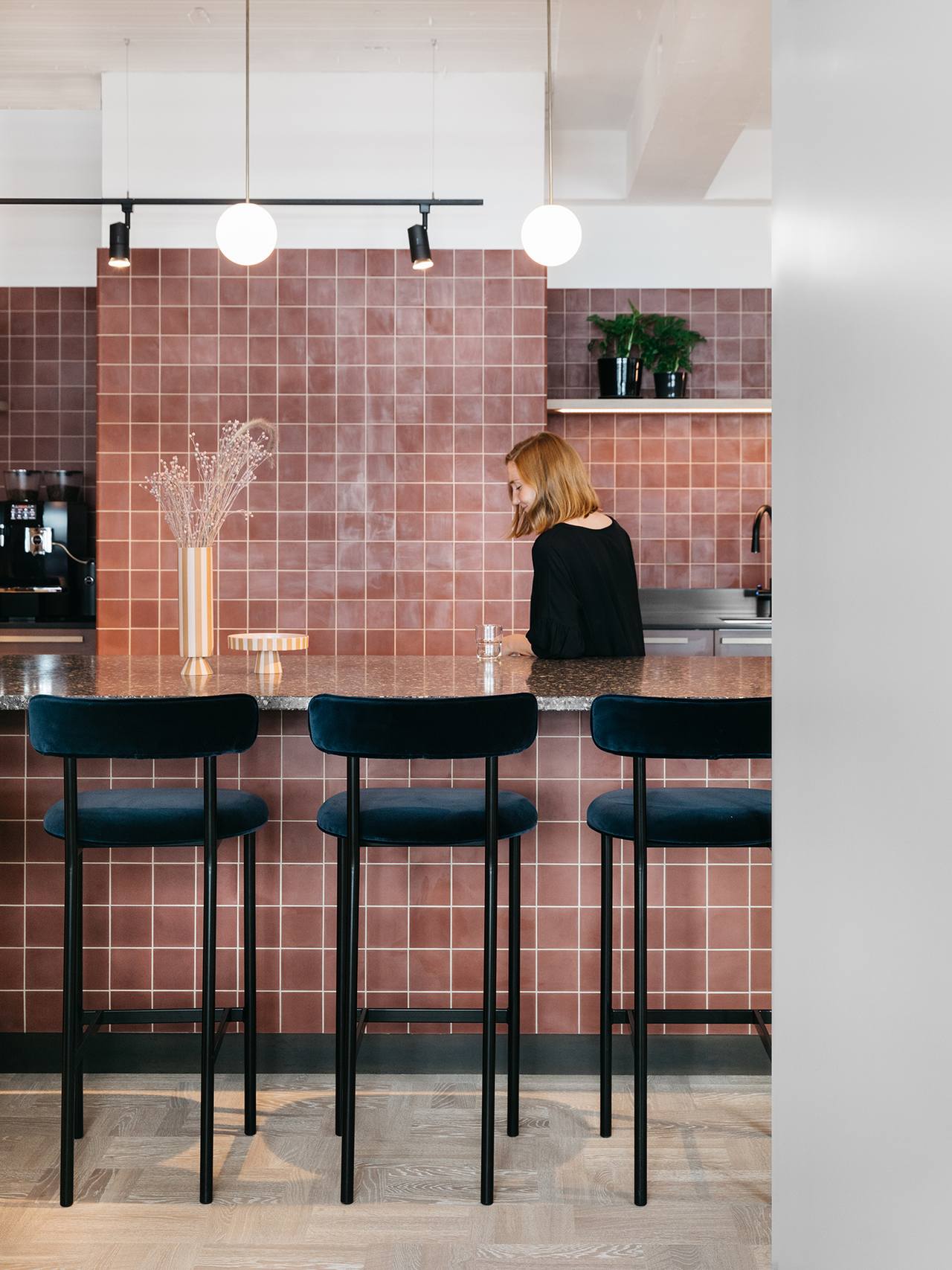 Kueche mit rotbraunen Zementfliesen und blauen Barhockern aus Samt