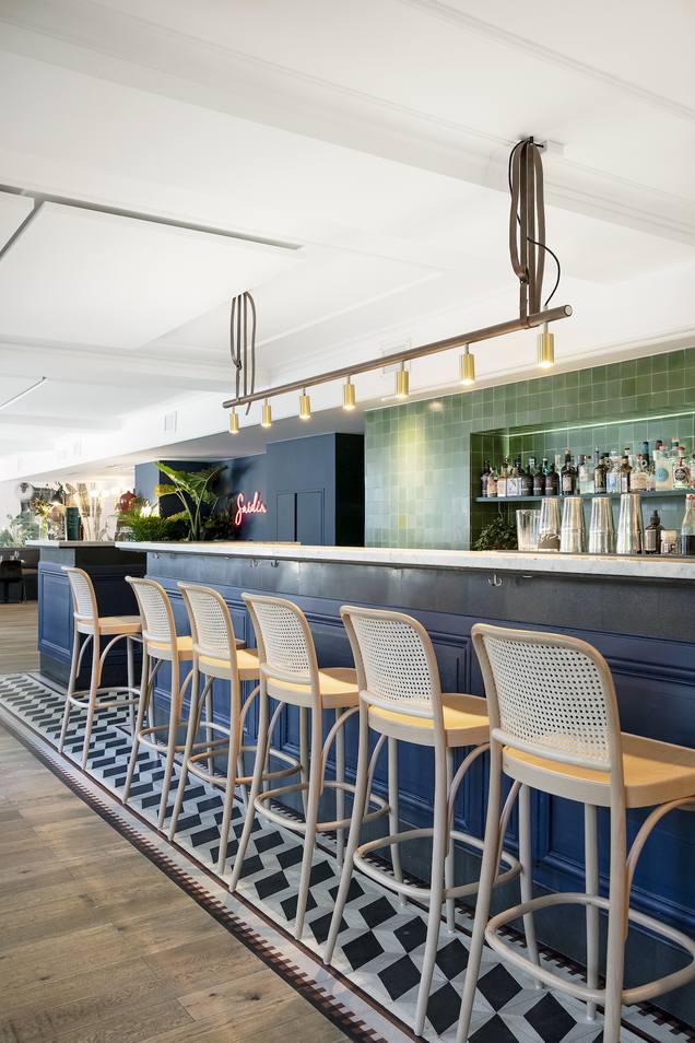 Bar mit schwarz weißen Terrazzoplatten und grünen Zementfliesen an der Wand