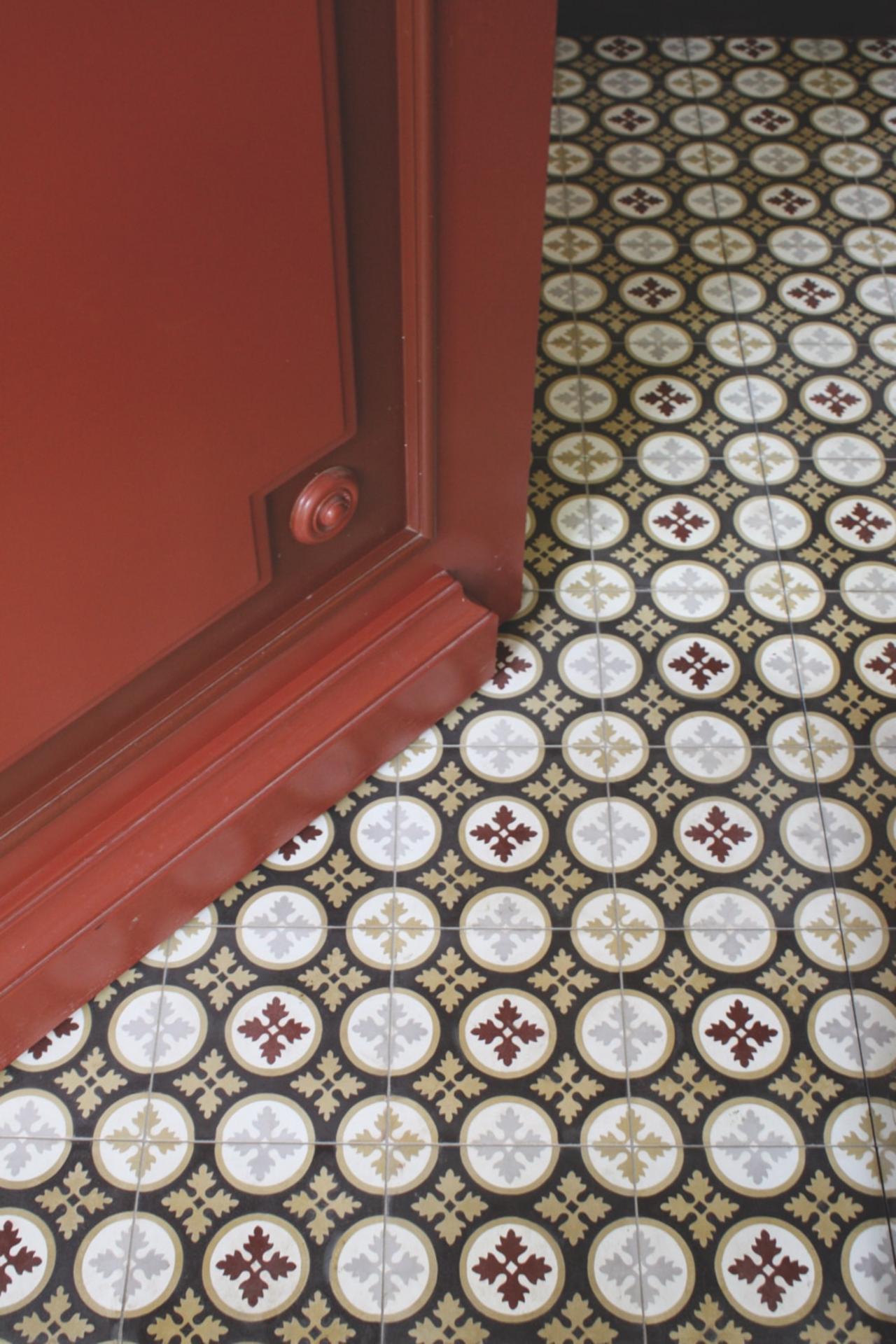 VIA Mehrfarbige kleinteilig gemusterte Zementfliese mit schwarzem Grund in einem Flur 