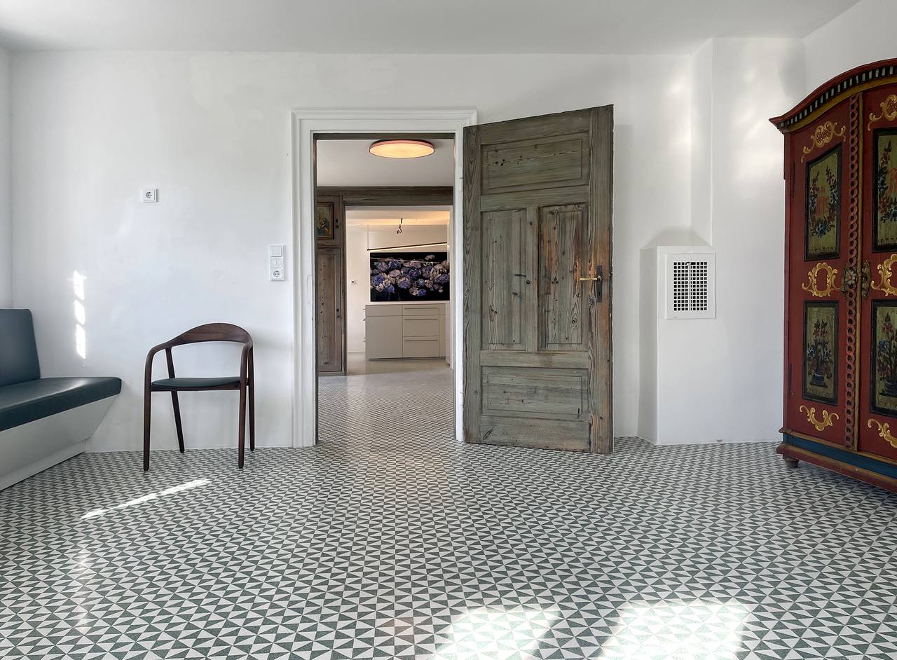 Terrazzodreiecksplatte in grün-weiß in Bauernhaus mit alter Holztüre 