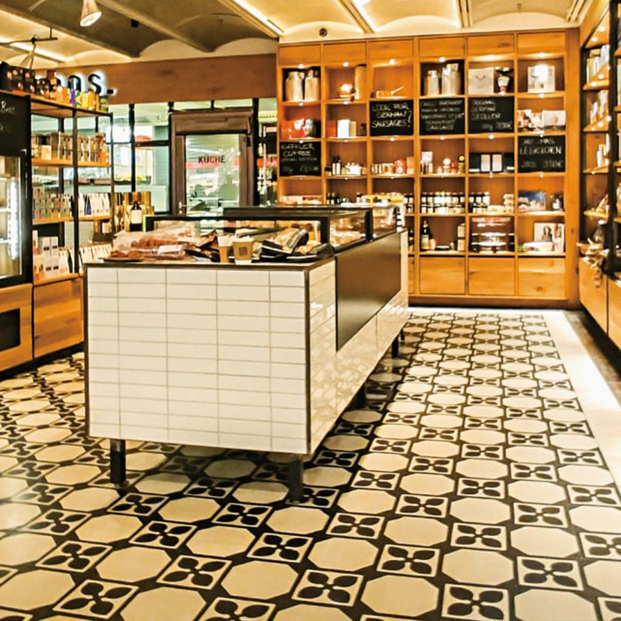 Diagonales Muster mit Terrazzofliesen mit Holzregalen im Flughafen Shop 