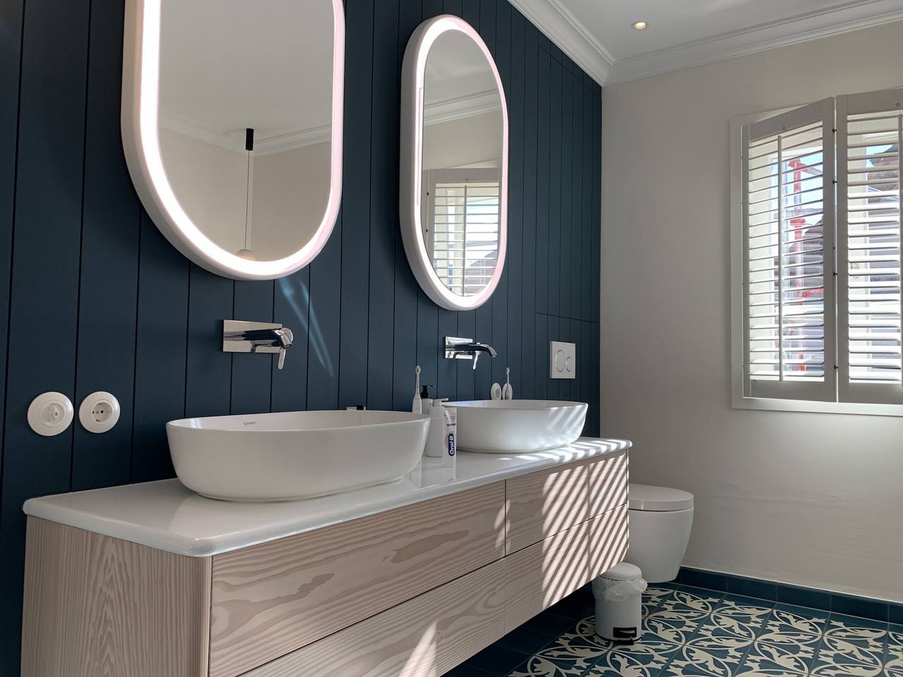 Badezimmer mit blauen Zementfliesen und blauer Holzwand 