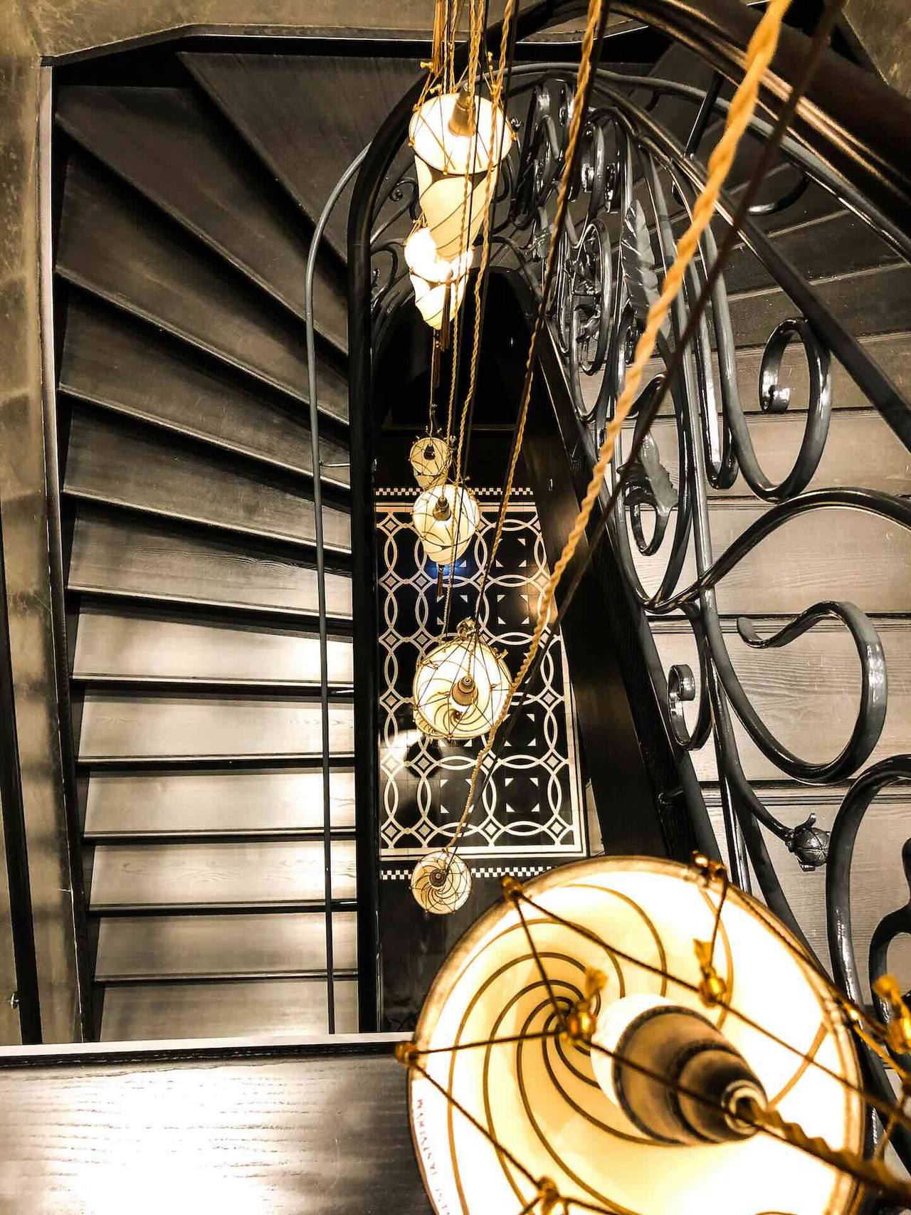 Elegantes Treppenhaus mit Terrazzoboden und Designleuchten 