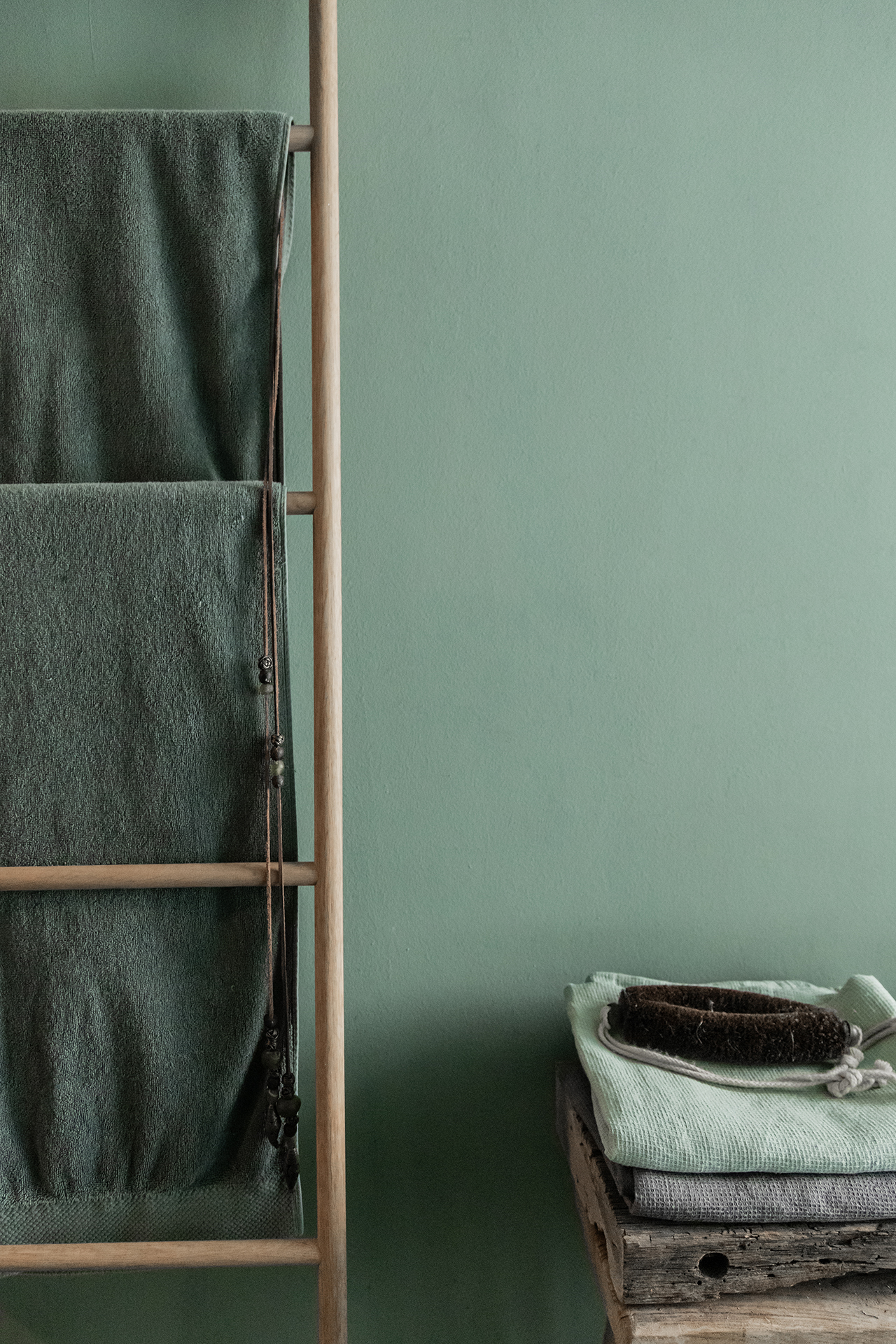 Badezimmer mit grünen Wänden Leiter als Handtuchhalter 