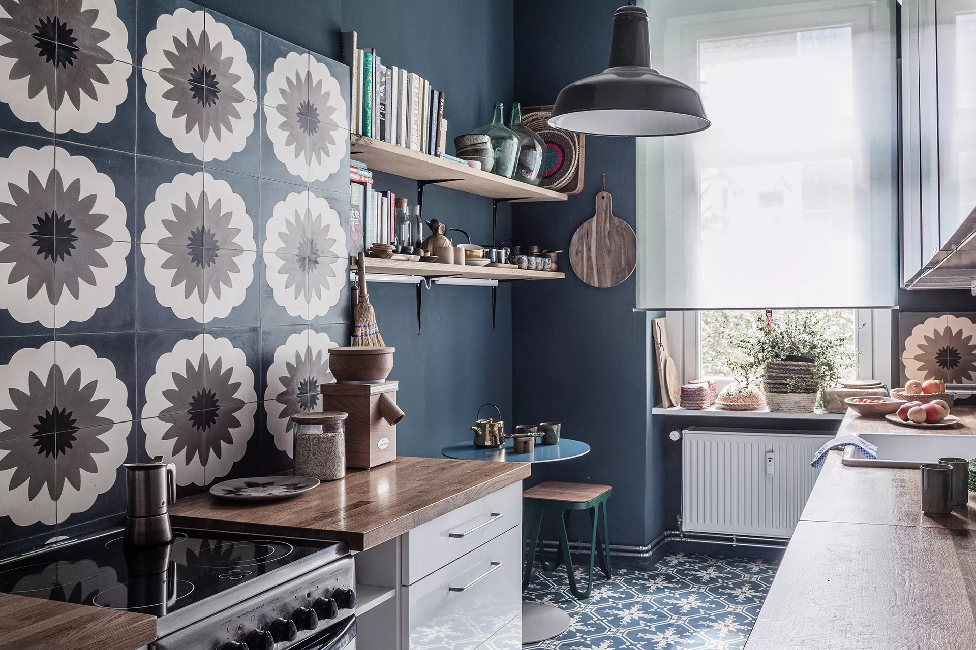 Küche mit Ornamentfliesen an der Wand und auf dem Boden und blauer Kreidefarbe an den Wänden