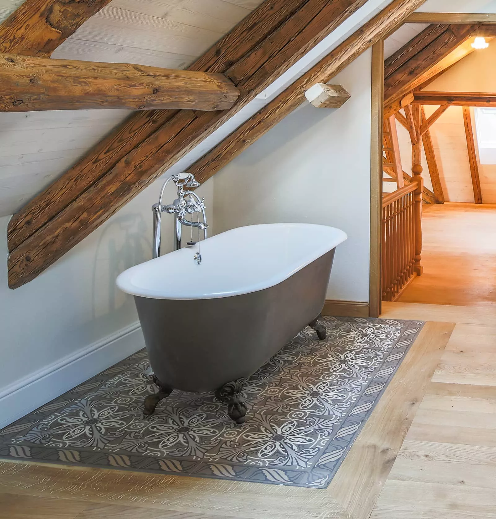 Badewanne auf Zementmosaikboden mit Holzumrahmung