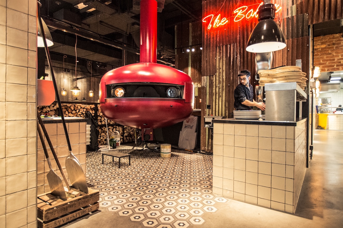 zementfliesen im Sechseck, darüber schwebender Pizzaofen