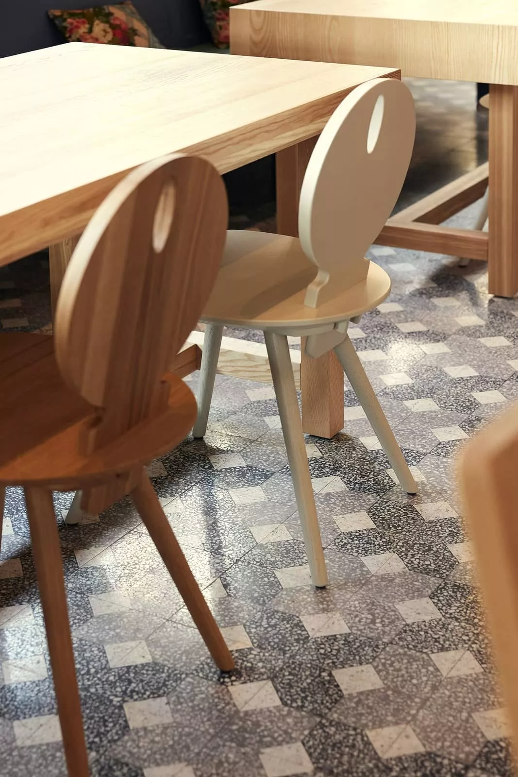 gemusterte Terrazzofliesen mit Stühlen und Tischen