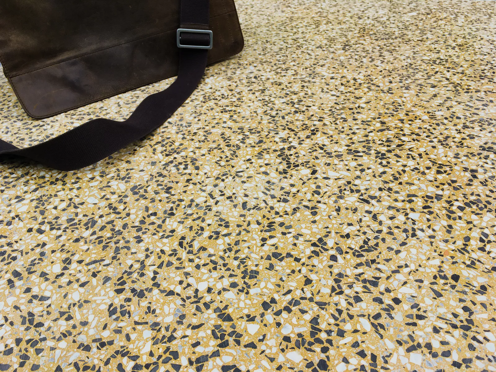 Terrazzoplatte fugenlos gelb mit Tasche darauf