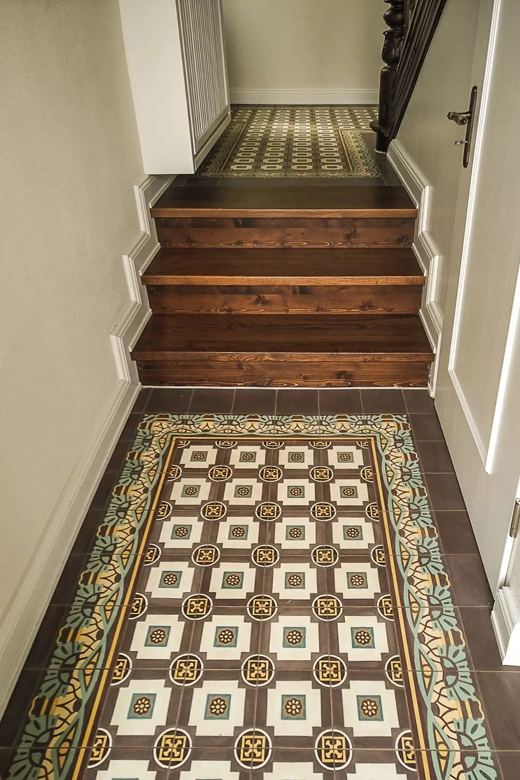 Zementfliesen im Flur mit Holztreppe