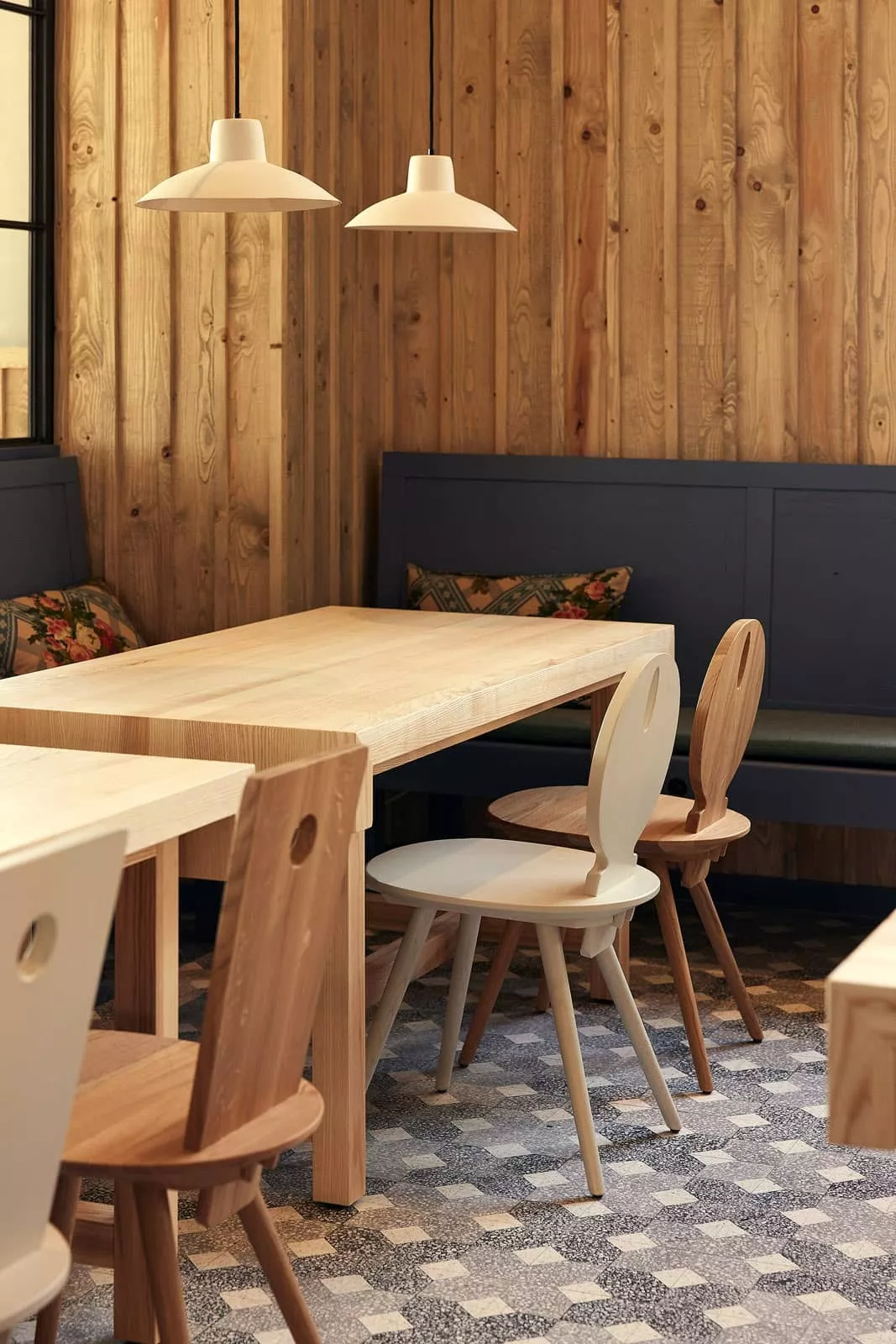 gemusterte Terrazzofliesen mit Stühlen und Tischen