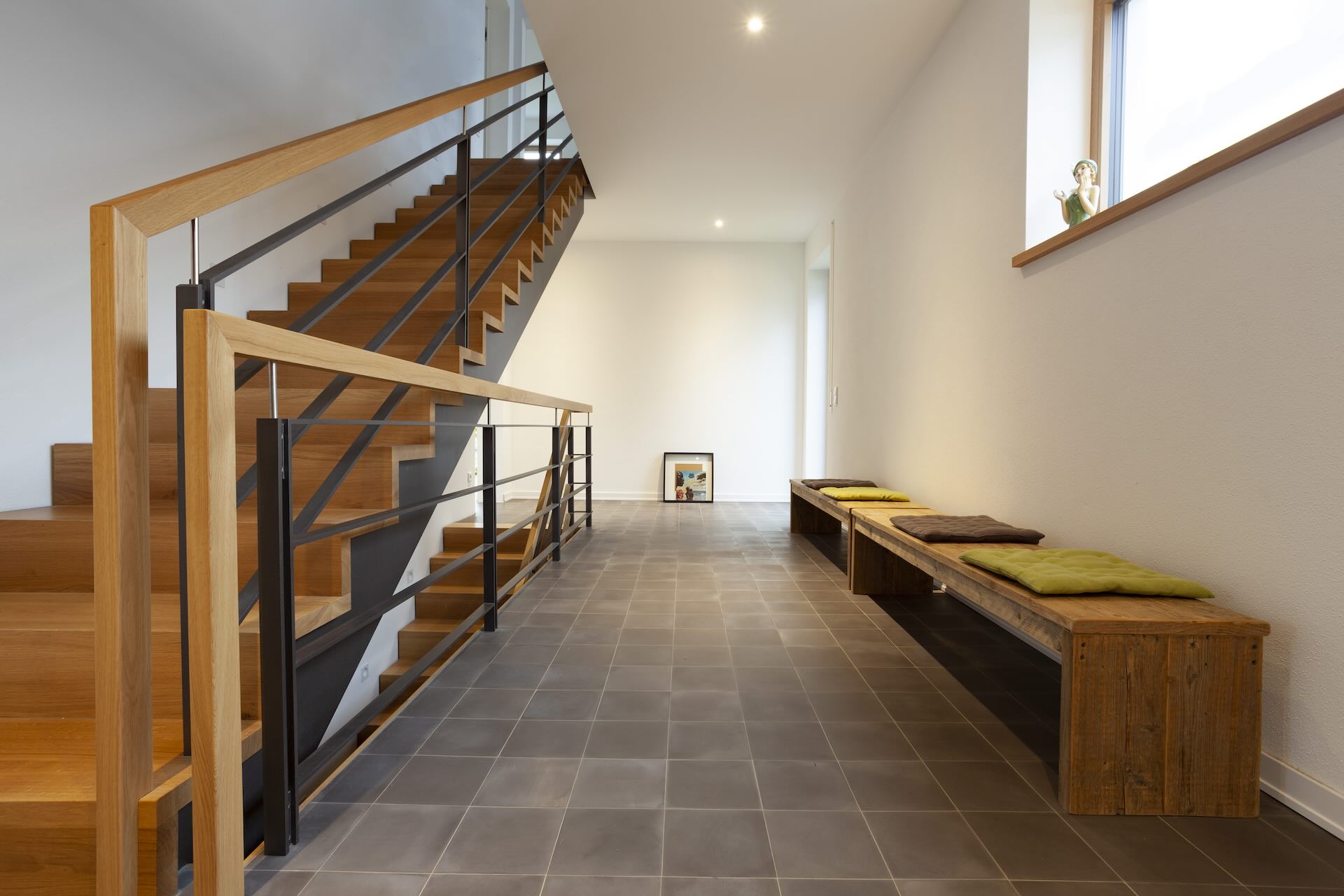 Zementfliese in Graubraun kombiniert mit Holz im Hausflur