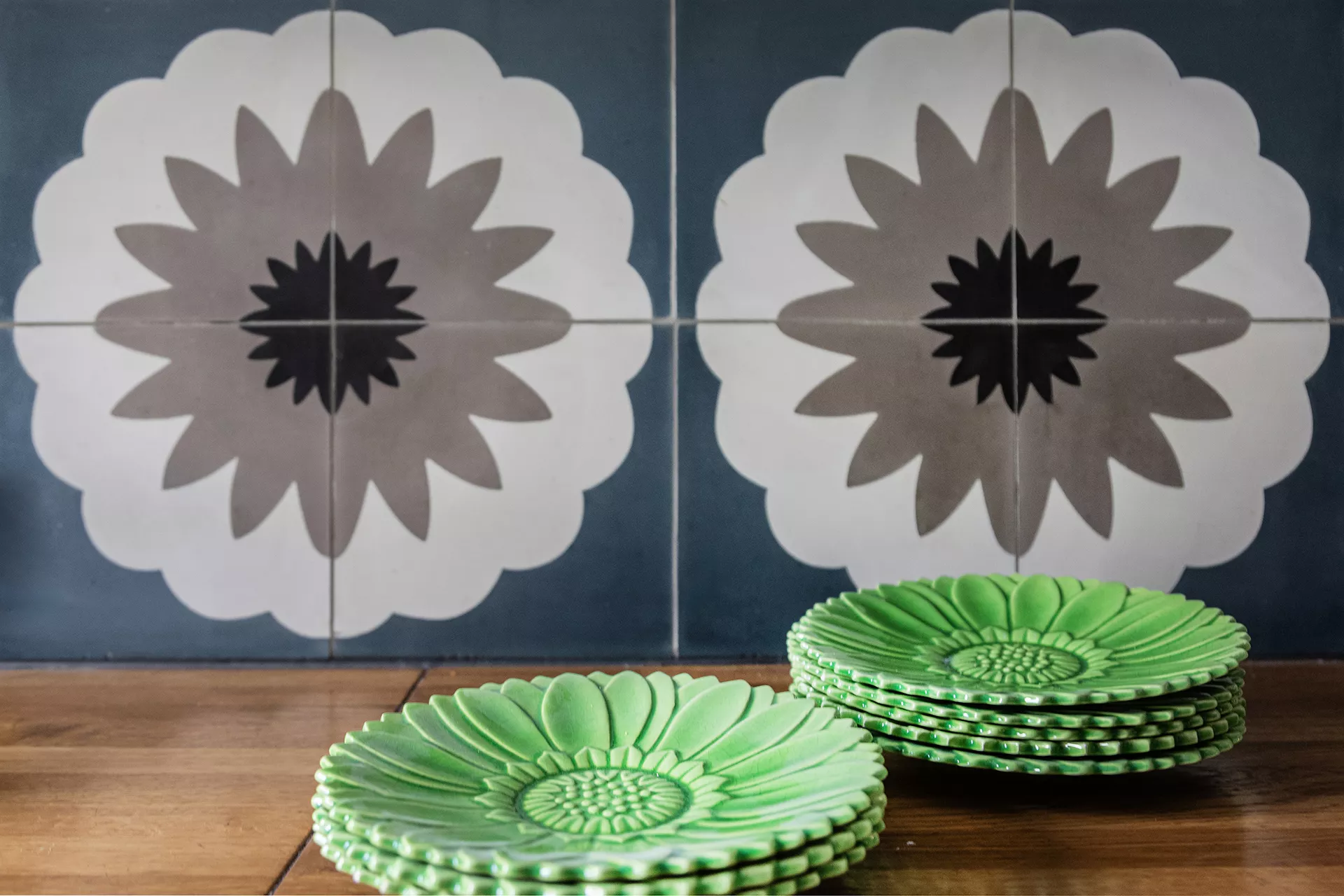 Jugendstil Ornamentplatte mit Blumenmuser und grüne Dessertteller auf einer Arbeitsplatte aus Holz