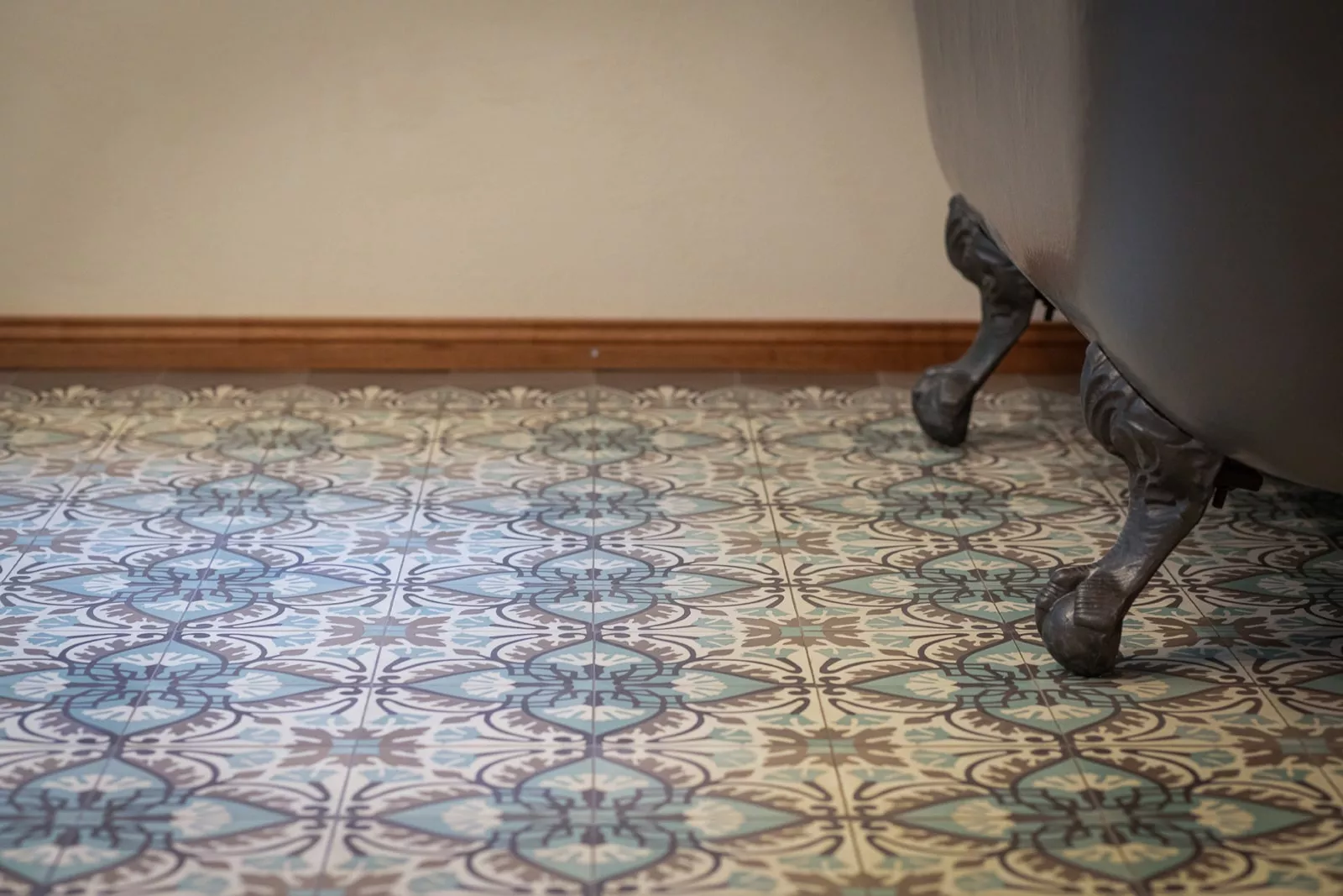 Badewanne auf Zementmosaikboden mit Holzleiste