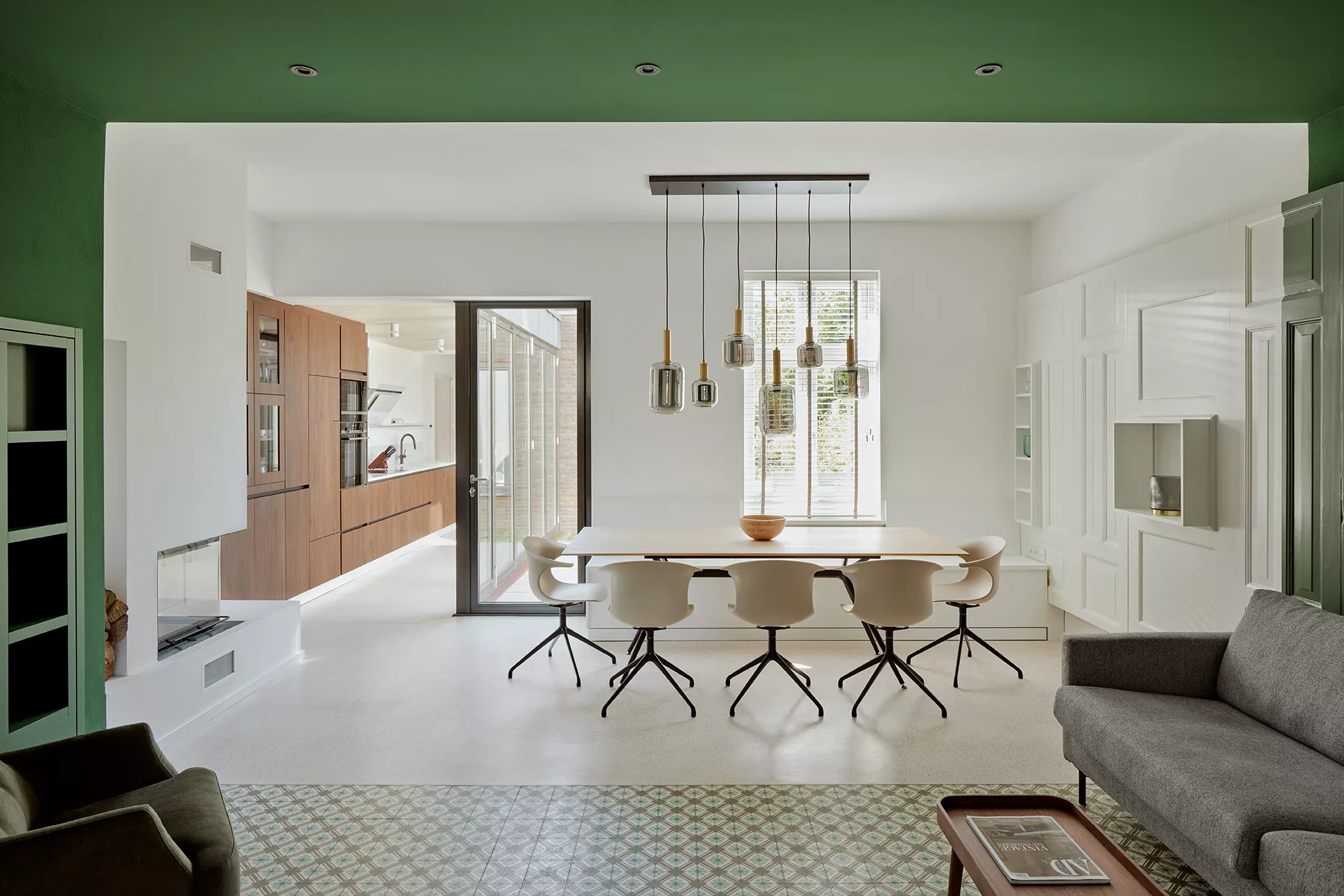 Ferienwohnung mit Zementfliesen im Wohnzimmer und Terrazzo in einem hellen Esszimmer mit Übergang zur Küche